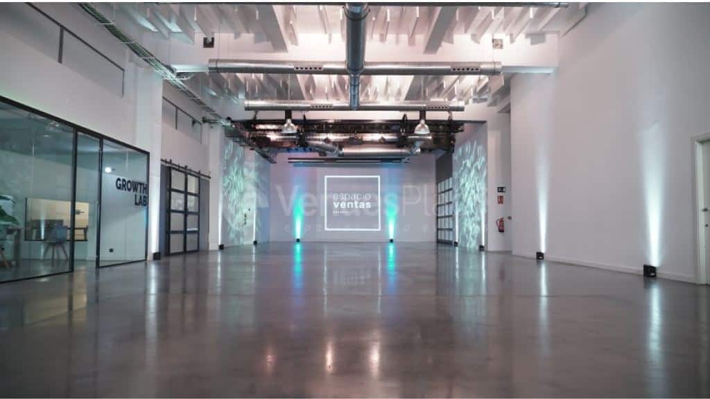Sala diáfana de Espacio Ventas, de estilo industrial, con suelo de hormigón pulido y techos altos